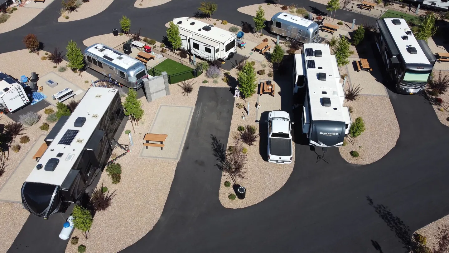 An aerial view of a campground with organized pitches, campervans and trailers.
